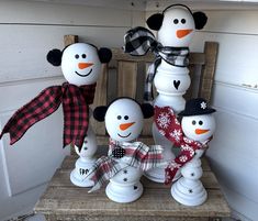 a group of snowmen sitting on top of a wooden chair next to each other