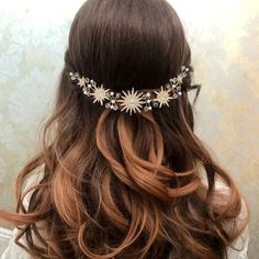 a woman with long brown hair wearing a flower headpiece on top of her head