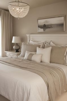 a bedroom with a chandelier hanging from the ceiling and a bed in front of a window