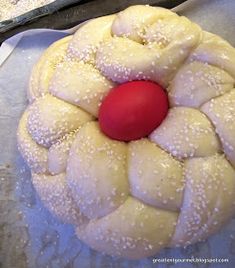 a pastry with white powdered sugar on it and a red ball in the middle