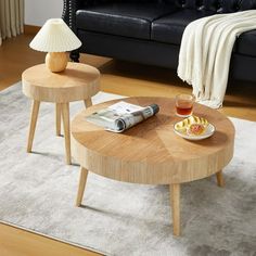 two wooden tables sitting on top of a white rug in front of a black couch