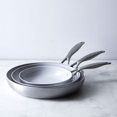 a set of four stainless steel utensils sitting on top of a marble counter