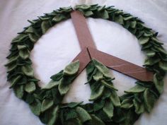 a peace sign made out of leaves on top of a white cloth covered tablecloth