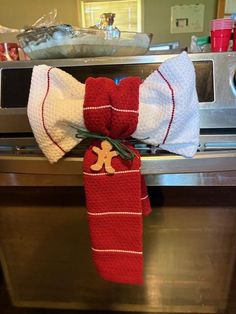 a red and white bow tie sitting on top of an oven