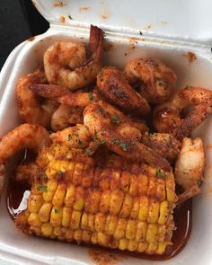 shrimp and corn on the cob in a foam container