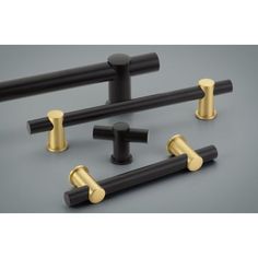 four black and gold knobs are shown in this image, with the handles on each side