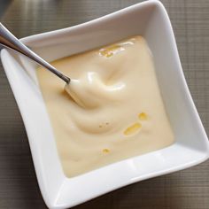 a white bowl filled with cream on top of a table