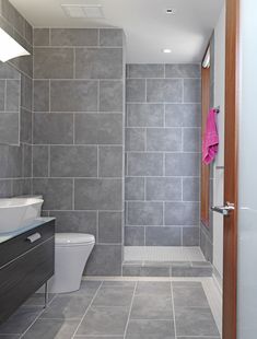 a bathroom with grey tiles and white fixtures