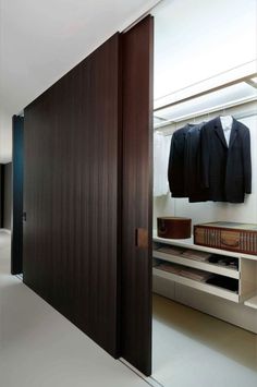 an open closet with clothes hanging on the wall