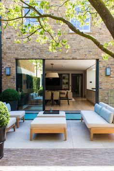 an outdoor living area with couches and tables