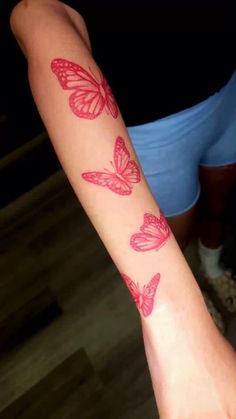 a woman's arm with pink butterflies on it