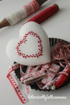 a heart - shaped object is sitting on a plate next to some other crafting supplies