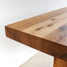 a close up of a wooden table with white walls in the backgroung