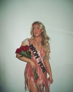 a woman with makeup on her face and body is dressed as a zombie holding roses