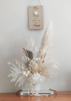 a vase filled with white flowers on top of a wooden table