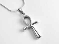 This ankh cross necklace, also known as the key of life, the key of the Nile or crux ansata, was the ancient Egyptian hieroglyphic character that read "life." It's made of 925 sterling silver. We recommend the curb link chain if this is being purchased for a male. The ankh necklace includes: - Ankh Pendant (measuring 26 x 16 mm) - A rope, snake, anchor or curb link chain (measuring 16 to 30 inches) ADD INITIAL CHARMS: https://etsy.me/3gMPv4r ADD BIRTHSTONE CHARMS: https://etsy.me/3gGTLT4 ADD BIR Spiritual Ankh Cross Necklace Gift, Ancient Egyptian Hieroglyphics, Ankh Pendant, Key Of Life, Ankh Necklace, Ankh Cross, Egyptian Hieroglyphics, Jewelry Card, Birthstone Charms