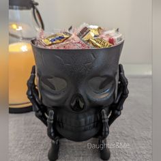 a skull shaped container filled with candy and candies