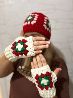 the woman is wearing two knitted christmas mitts