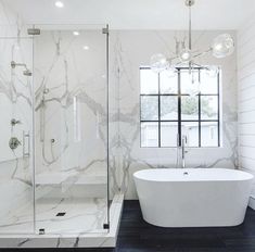 a white bath tub sitting next to a walk in shower