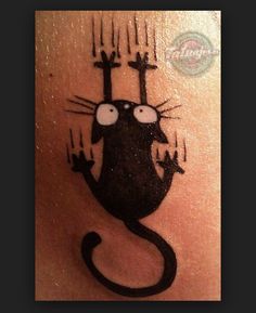 a black cat tattoo on the back of a person's leg with two candles in it