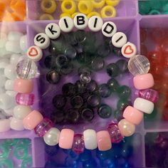 a box filled with lots of different colored beads and letters that spell out the word kidd