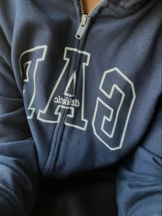 a close up of a person wearing a sweatshirt with the letters g and l on it