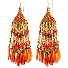 two pairs of red and gold earrings with dangling beads on them, one is hanging from the