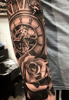 a man's arm with a clock and rose tattoo on it