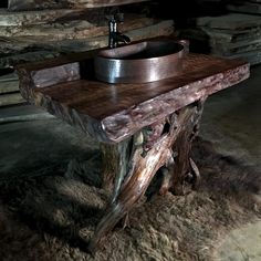 a rustic sink made out of wood with a bowl on the top and an old fashioned faucet