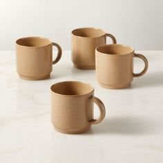 four coffee mugs sitting on top of a white counter