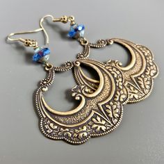 "Large Brass Hoop Earrings - Oval Embossed Brass Stampings with an Ornate Pattern dangle from beautiful Blue Czech Glass Beads. Earrings are 48mm x 44mm (1.75\" long x just under 2\" at widest point) and have hollow backs. That makes them lightweight for easy wearing. Earrings measure just under 3\" from top of earwires to bottom. Antiqued brass earwires" Blue Brass Hoop Earrings, Brass Beaded Drop Earrings For Pierced Ears, Ornate Metal Hoop Earrings Gift, Vintage Blue Hoop Earrings For Gift, Blue Vintage Hoop Earrings As Gift, Blue Vintage Hoop Earrings For Gift, Blue Vintage Hoop Earrings For Gifts, Ornate Metal Earrings With Ear Wire, Blue Brass Hoop Earrings As Gift