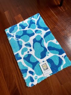 a blue and white rug sitting on top of a wooden floor