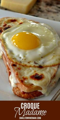 a close up of a plate of food with cheese and an egg in the middle