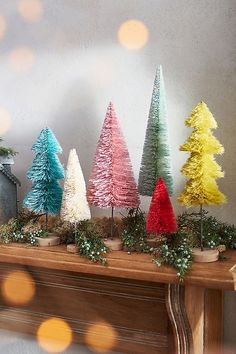 christmas trees are lined up on a mantle