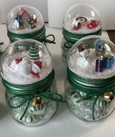 four glass jars filled with ornaments on top of a table