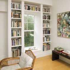 a living room filled with furniture and bookshelves next to a window covered in books