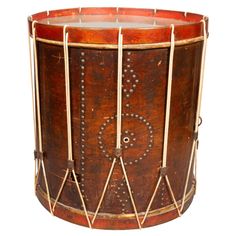 an old wooden drum with metal bars on the sides and holes in the middle, isolated against a white background