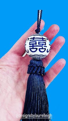 a hand holding a blue and white tassel