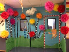 an office cubicle decorated with paper pom poms and pictures on the wall