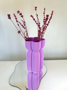 a purple vase that has some flowers in it