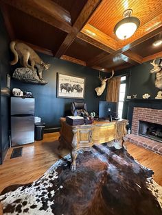 a living room filled with furniture and a fire place next to a wall mounted deer heads