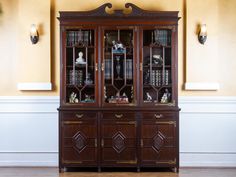 an antique bookcase with glass doors in a room