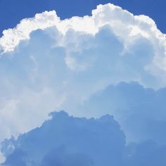 an airplane is flying through the clouds in the blue sky on a sunny day,