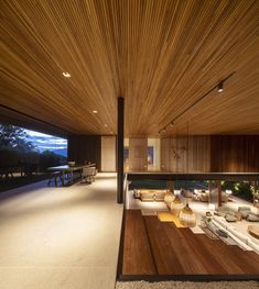 the interior of a modern house with wood paneling on the walls and ceiling is lit by recessed lights