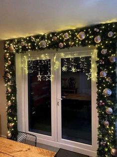 a room with christmas lights and decorations on the wall, along with sliding glass doors