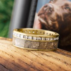 a close up of a ring on a wooden table with a dog in the background