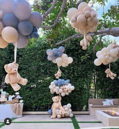 balloons and teddy bears are hanging from the trees