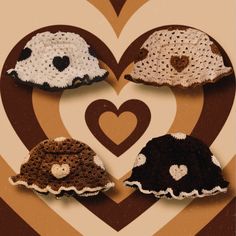 crocheted hats are arranged in the shape of a heart on a brown and white background