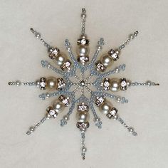 a snowflake made up of silver and white beads