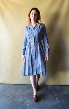 A vintage 1930s cotton dress with buttons down the front, long cuffed sleeves, a collar, and a breast pocket. The blue floral print fabric feels like cotton feedsack. Size: small to medium Bust: 42" (meant to have some drape) Waist: 31" (high waist approximately 14" below shoulder) Hip: 48" (meant to drape) Length: 40" in front and 44" in back Shoulder (from shoulder seam to seam): 15" Sleeve length: 23" Condition: Very good. Sewing imperfections/visible seam stitching commensurate with homemade nature of garment. Flaws are only noticeable if you are looking for them. Feedsack Dresses, Feedsack Dress, 30s Dress, Dress With Buttons, Floral Print Fabric, Feed Sacks, Blue Floral Print, Back Shoulder, Dress Vintage